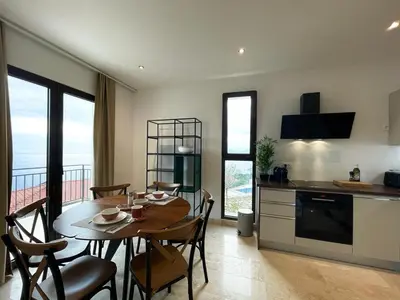 a kitchen and dining room with a table and chairs at Family Vacation Villa Rezevici in Budva