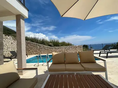 a patio with a couch and a swimming pool at Family Vacation Villa Rezevici in Budva