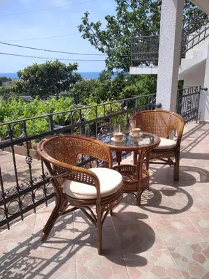 two wicker chairs and a table on a patio at ApartToni in Dobra Voda
