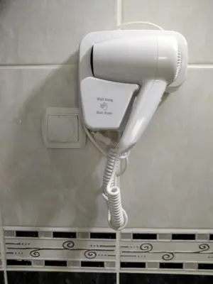 a white phone hanging on a wall in a bathroom at ApartToni in Dobra Voda