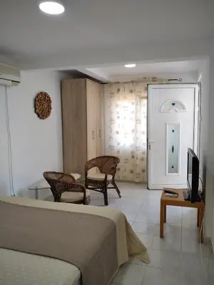 a bedroom with a bed and a table and a television at ApartToni in Dobra Voda