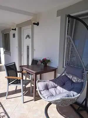 a porch with a rocking chair and a table at ApartToni in Dobra Voda