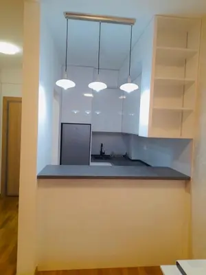 a kitchen with white cabinets and blue counter top at Lux studio apartment Bečići-Budva in Budva