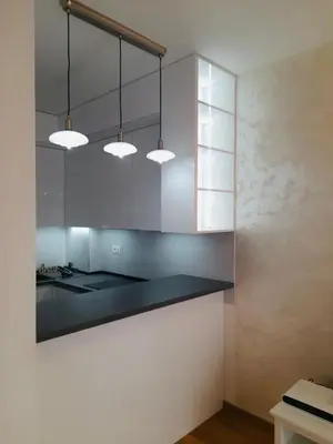 a kitchen with white cabinets and a black counter top at Lux studio apartment Bečići-Budva in Budva