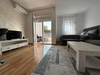 a living room with a couch and a table at Lux studio apartment Bečići-Budva in Budva