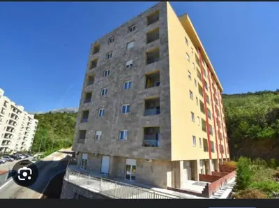a large brick building with windows on a street at Lux studio apartment Bečići-Budva in Budva