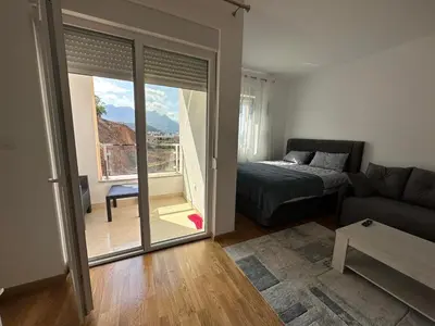 a living room with a bed and a sliding glass door at Lux studio apartment Bečići-Budva in Budva