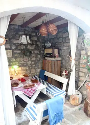 a room with a table and chairs in a stone house at Best Location Old Town Budva Rooms in Budva