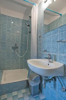 a blue tiled bathroom with a sink and a shower at Best Location Old Town Budva Rooms in Budva