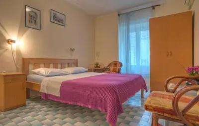 a bedroom with a bed with a pink blanket at Best Location Old Town Budva Rooms in Budva