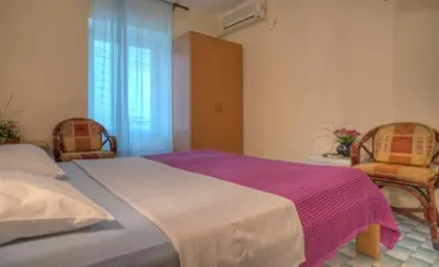 a bedroom with a large bed and two chairs at Best Location Old Town Budva Rooms in Budva