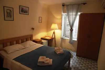 a bedroom with a bed with two slippers on it at Best Location Old Town Budva Rooms in Budva