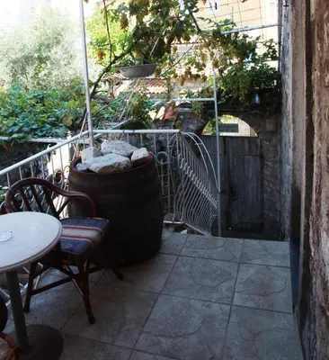 a patio with a table and chairs and a barrel at Best Location Old Town Budva Rooms in Budva