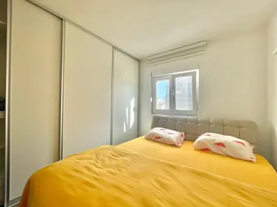 a bedroom with a large yellow bed with two pillows at Family One bedroom apartment with Garden view in Budva