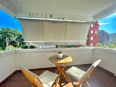 a table and two chairs on a balcony with a curtain at Family One bedroom apartment with Garden view in Budva