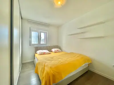 a bedroom with a bed with yellow sheets and a window at Family One bedroom apartment with Garden view in Budva