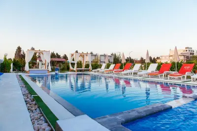 a large swimming pool with lounge chairs in a hotel at Apartments Paradise in Ulcinj