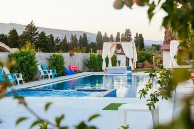 a swimming pool with blue chairs and a tent at Apartments Paradise in Ulcinj