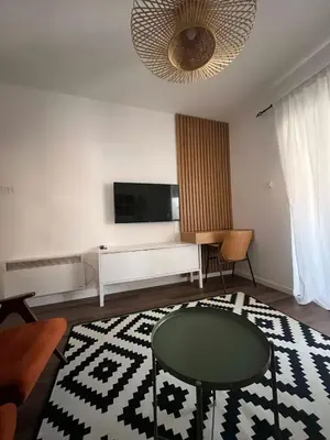 a living room with a tv and a glass table at Lamada One Bedroom Apartment in Budva