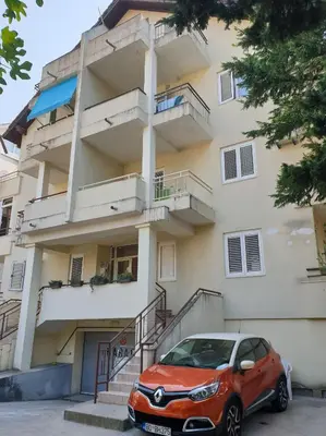 a red car parked in front of a building at Lamada One Bedroom Apartment in Budva