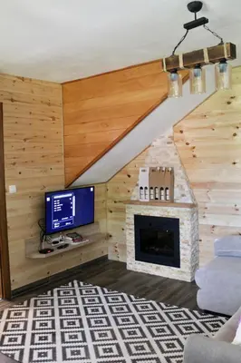 a living room with a tv and a fireplace at Mountain Village House in Cetinje