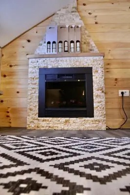 a fireplace in a living room with a rug at Mountain Village House in Cetinje