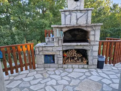 a stone fireplace with a pile of wood in it at Mountain Village House in Cetinje