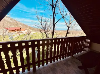a balcony with a view of a house on a mountain at Mountain Village House in Cetinje