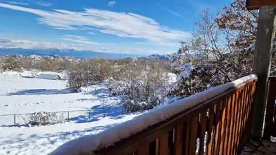 a snow covered deck with a view of the mountains at Mountain Village House in Cetinje