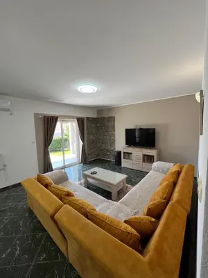 a large brown couch in a living room at Cezar Apartment 3 in Podgorica