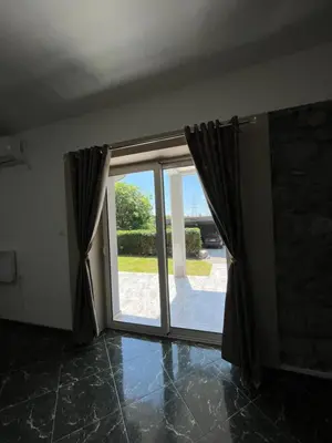 an empty room with a large glass door at Cezar Apartment 3 in Podgorica