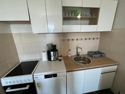 a small kitchen with white cabinets and a sink at Cezar Apartment 3 in Podgorica