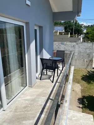 a patio with a table and chairs on a house at Cezar Apartment 3 in Podgorica