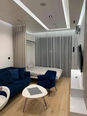 a living room with a blue couch and a bed at Blue View Luxury Apt in Soho City in Bar