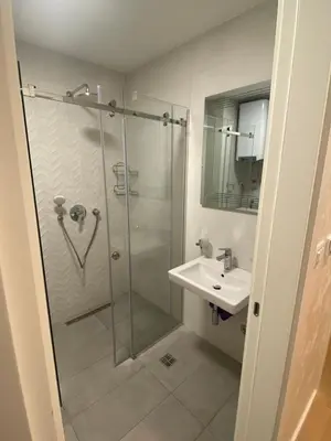 a bathroom with a glass shower and a sink at Blue View Luxury Apt in Soho City in Bar