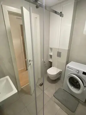 a bathroom with a washing machine and a toilet at Blue View Luxury Apt in Soho City in Bar
