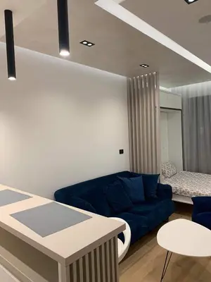 a living room with a blue couch and a table at Blue View Luxury Apt in Soho City in Bar