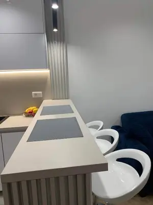 a room with a table and four white chairs at Blue View Luxury Apt in Soho City in Bar