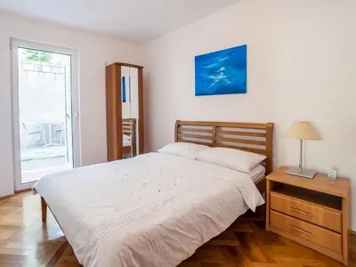 a bedroom with a bed and a desk and a window at Apartment Skada in Sveti Stefan