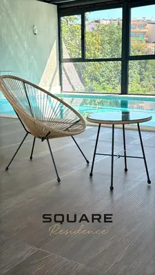 a rattan chair and a table in a room at Square Residence & Pool in Ulcinj