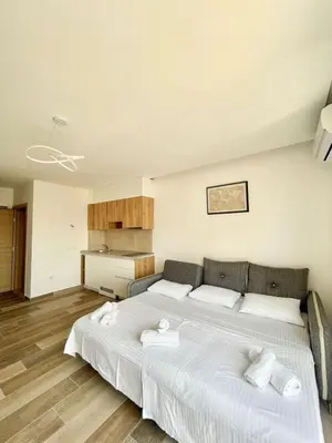 a bedroom with a large white bed with towels on it at Square Residence & Pool in Ulcinj