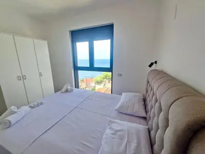 a large bed in a room with a large window at Square Residence & Pool in Ulcinj