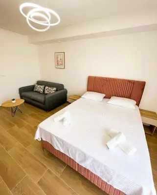 a bedroom with a large bed and a couch at Square Residence & Pool in Ulcinj