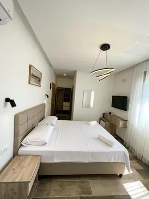 a bedroom with a large bed and a television at Square Residence & Pool in Ulcinj