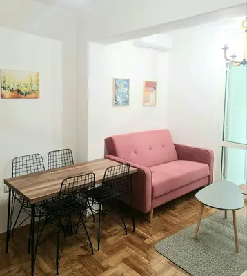 a living room with a pink couch and a table at Apartman GD in Budva
