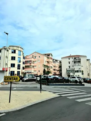 a city street with cars parked in a parking lot at Apartman GD in Budva