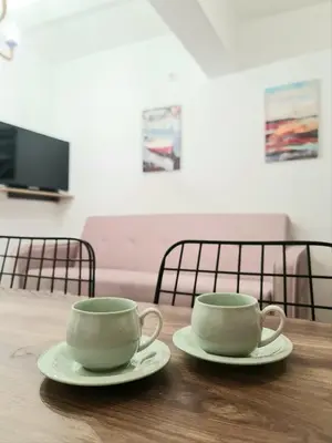 two coffee cups sitting on a wooden table at Apartman GD in Budva