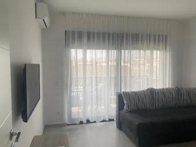 a living room with a couch and a large window at Miran San in Donji Štoj