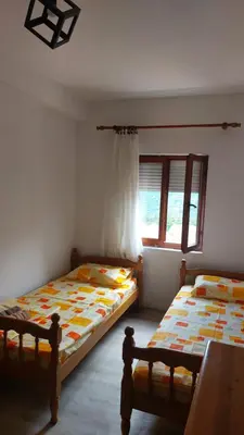 a bedroom with two beds and a window at Guest House Vodica in Virpazar
