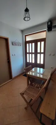 a dining room with a glass table and chairs at Guest House Vodica in Virpazar